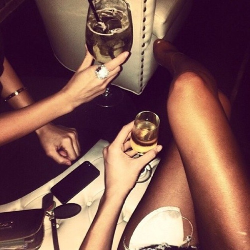 Две девушки с татуировками пьют шампанское