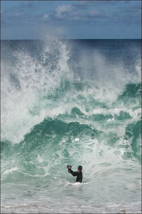 Человек который фотографирует волны