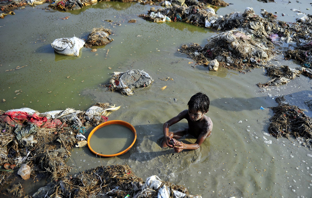 Поиск монет и золота в мутных водах индийского Ганга