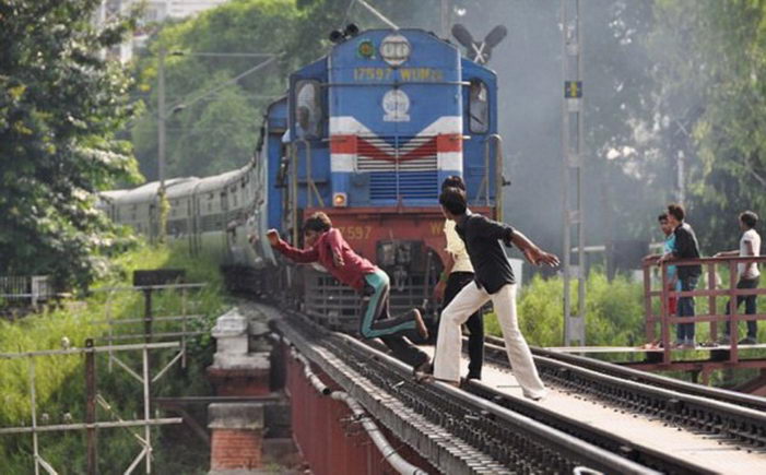 Индийские подростки развлекаются прыжками с моста перед поездом