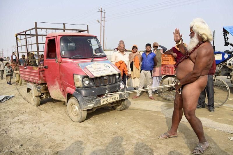 Голый монах развлекает прохожих, таская членом грузовик