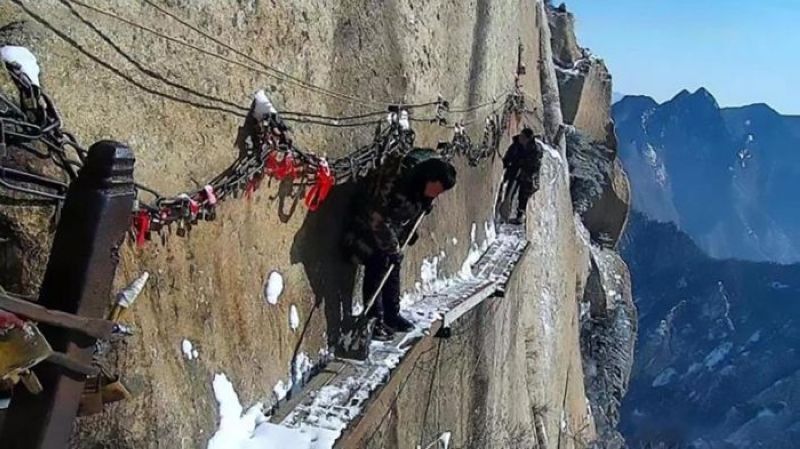 Китайские дворники чистят от снега горную тропку на высоте 700 метров