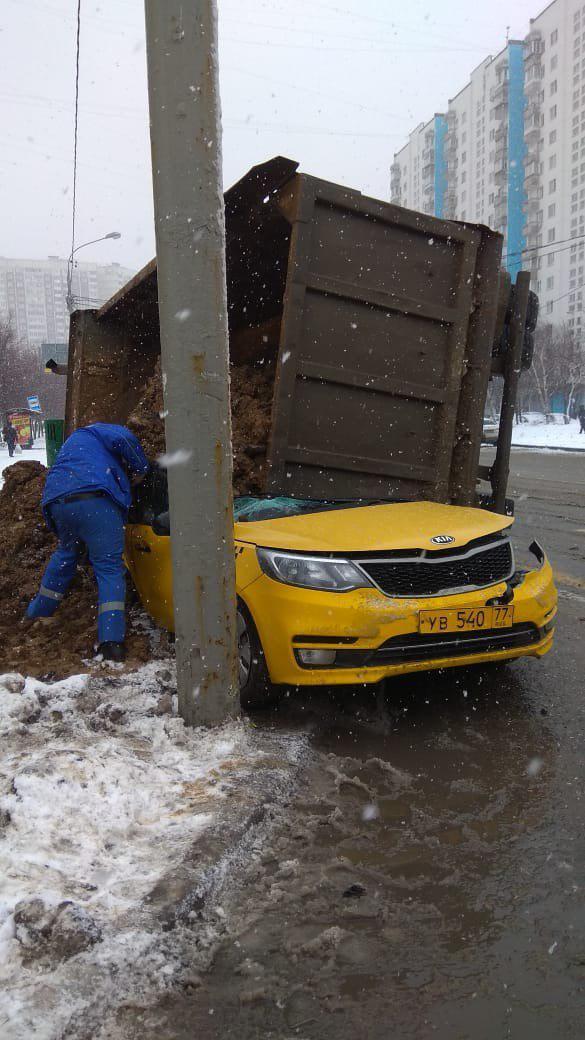 Груженный песком КамАЗ опрокинулся на такси в Москве
