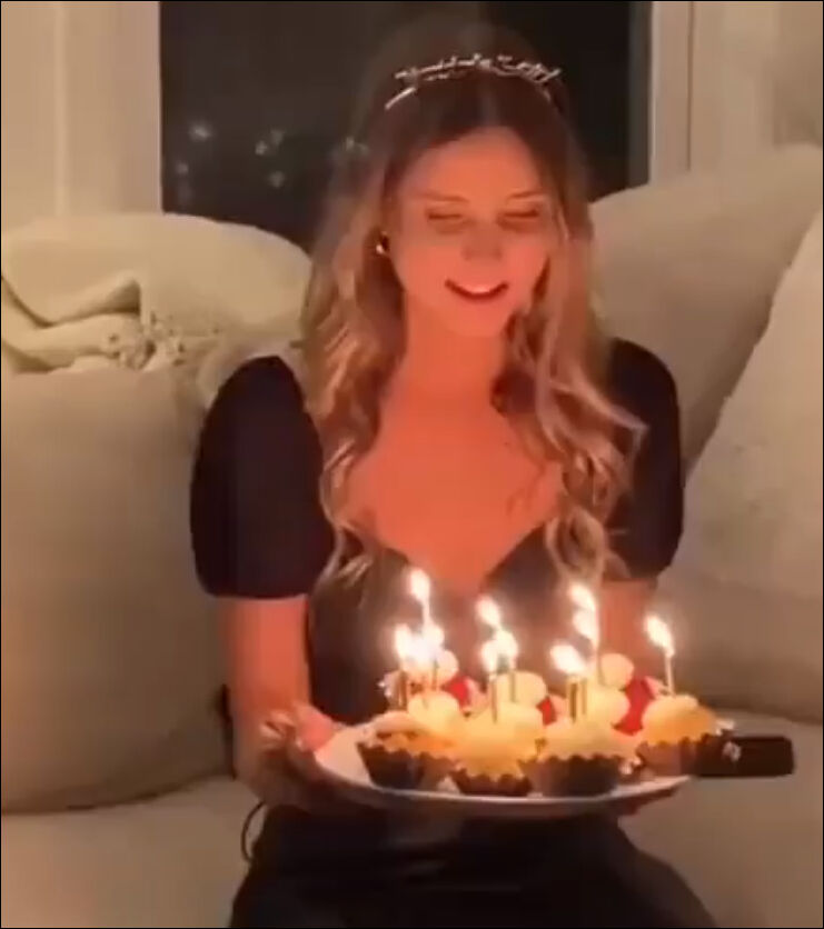 Девушка задувает свечи.