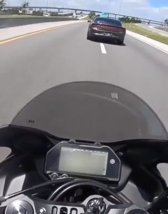 Заботливый коп проверяет тормоза у мотоцикла