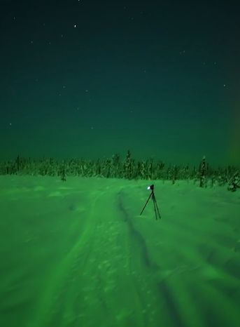 Яркое северное сияние, окрашивающее всю землю в зеленый цвет