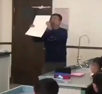 Учитель физики демонстрирует, как можно контролировать полет бумажного самолетика, создавая восходящий поток воздуха с помощью листа бумаги
