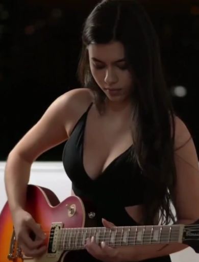 Девушка демонстрирует свои навыки игры на гитаре