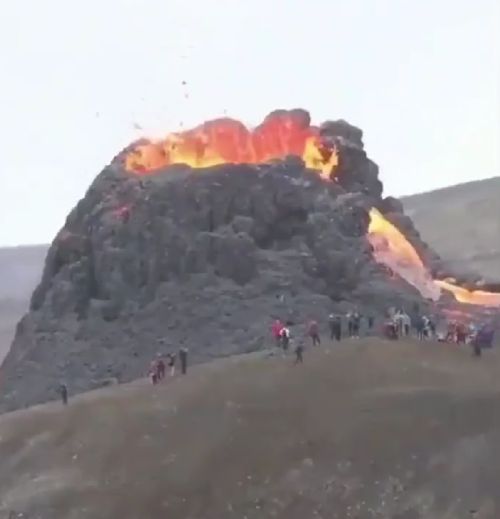 Туристы возле извергающегося вулкана в Исландии