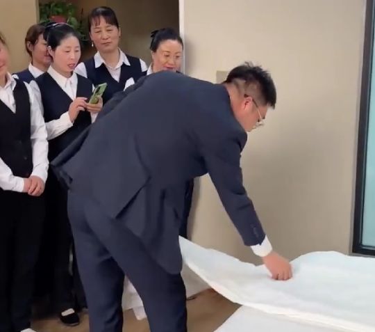 Менеджер отеля обучает персонал искусству заправки постелей