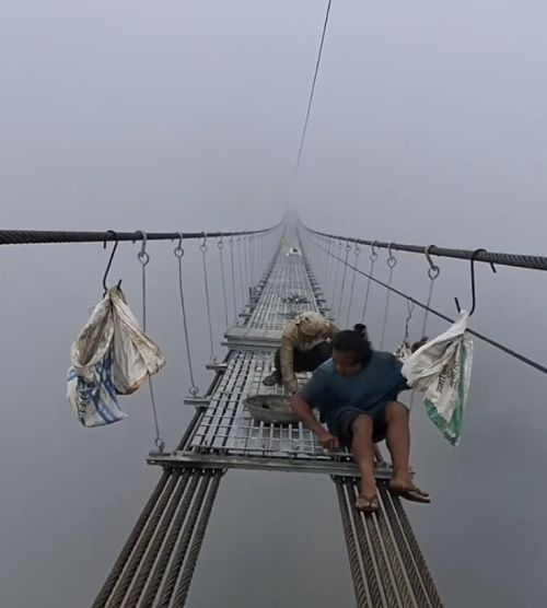 Рабочие строят подвесной мост в Непале на экстремальной высоте в густом тумане